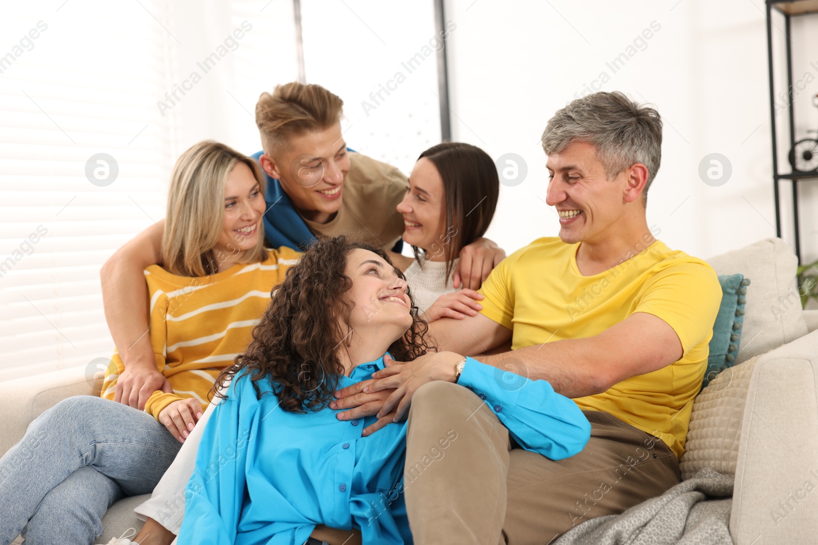 Happy friends hugging on sofa at home Photo of Happy friends hugging on sofa at home