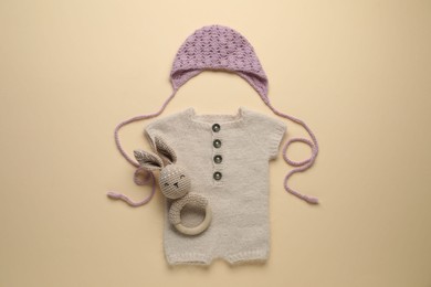 Photo of Baby clothes and accessory on beige background, flat lay