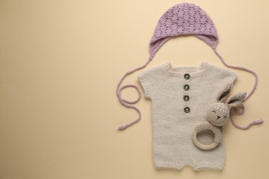 Photo of Baby clothes and accessory on beige background, flat lay. Space for text