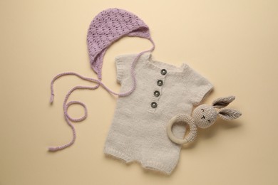 Photo of Baby clothes and accessory on beige background, flat lay