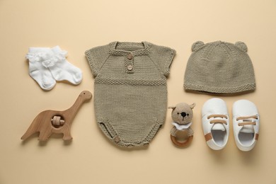 Photo of Baby clothes and accessories on beige background, flat lay