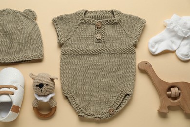 Photo of Baby clothes and accessories on beige background, flat lay