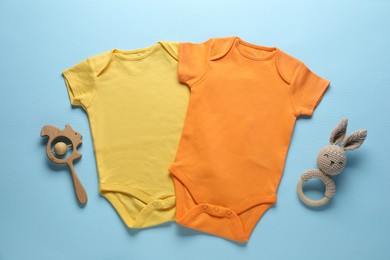 Photo of Baby clothes and accessories on light blue background, flat lay