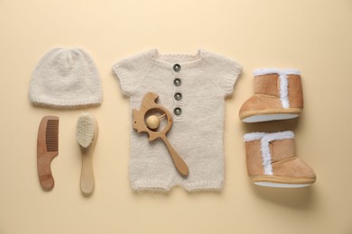 Photo of Baby clothes and accessories on beige background, flat lay