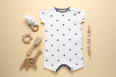 Photo of Baby romper and accessories on beige background, flat lay