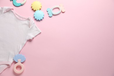 Photo of Baby onesie and accessories on pink background, flat lay. Space for text