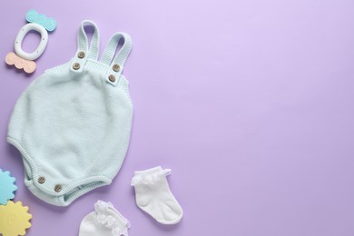 Photo of Baby clothes and accessories on violet background, flat lay. Space for text