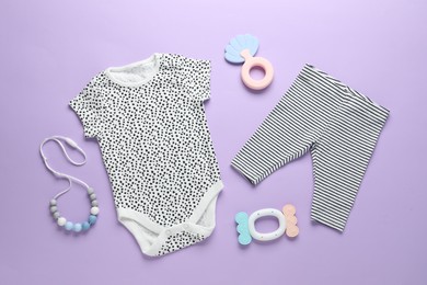 Photo of Baby clothes and accessories on violet background, flat lay