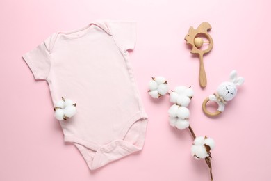 Photo of Baby onesie, cotton flowers and accessories on pink background, flat lay