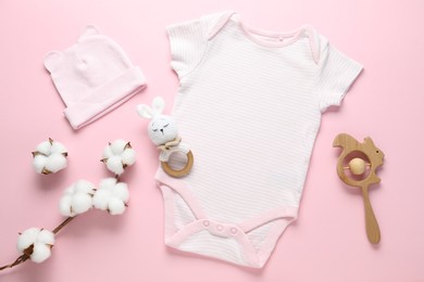 Photo of Baby clothes, cotton flowers and accessories on pink background, flat lay