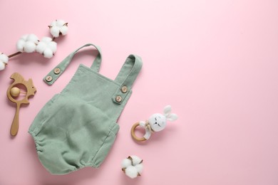 Photo of Baby onesie, cotton flowers and accessories on pink background, flat lay. Space for text