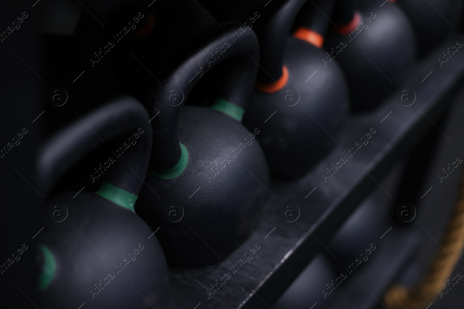 Many kettlebells on stand in gym, closeup Photo of Many kettlebells on stand in gym, closeup