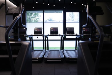 Photo of Many modern professional treadmills in gym. Healthy lifestyle