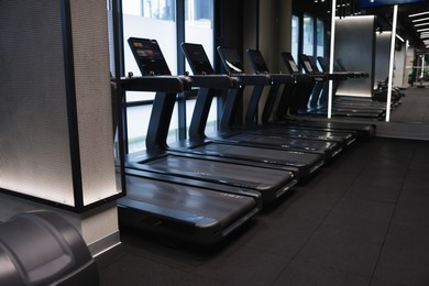 Photo of Many modern professional treadmills in gym. Healthy lifestyle