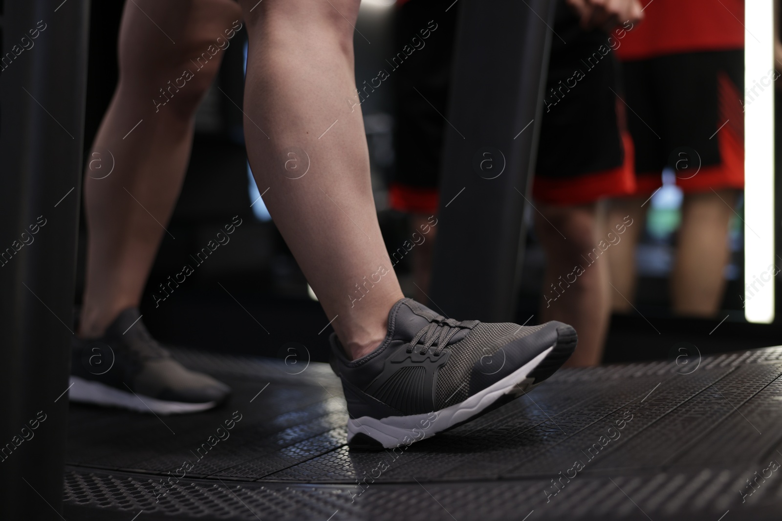 Young woman exercising on treadmill with professional personal trainer in gym, closeup Photo of Young woman exercising on treadmill with professional personal trainer in gym, closeup