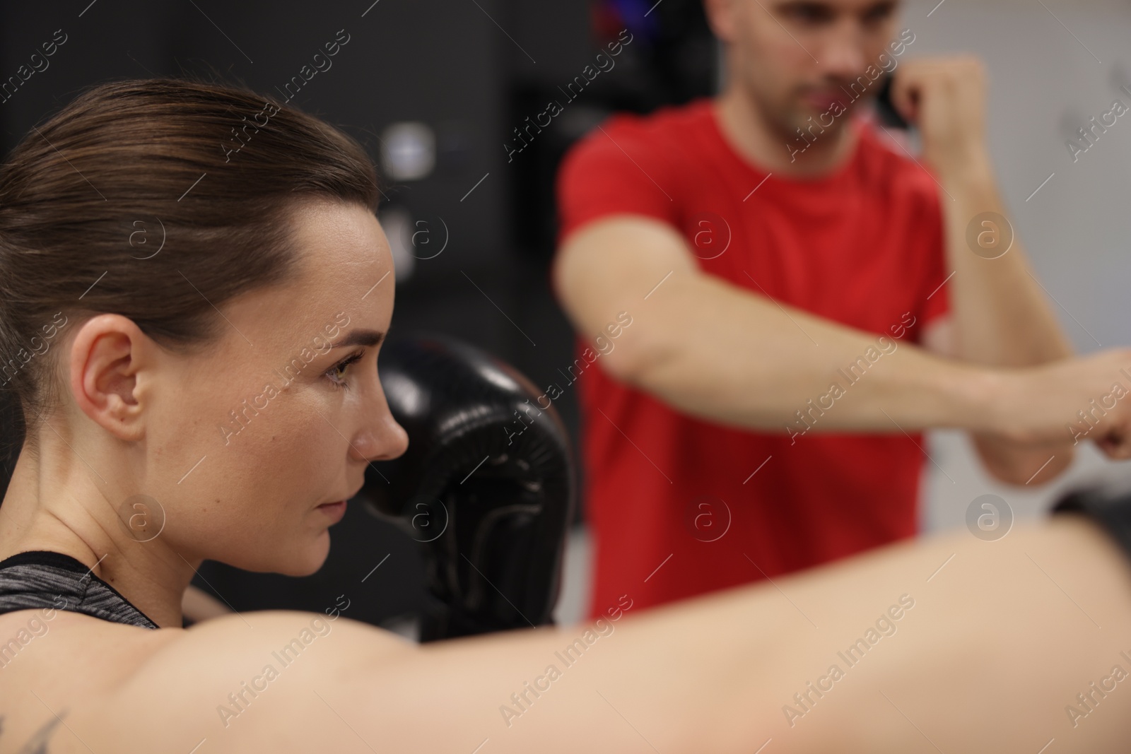 Young woman exercising with professional personal trainer in gym, closeup Photo of Young woman exercising with professional personal trainer in gym, closeup