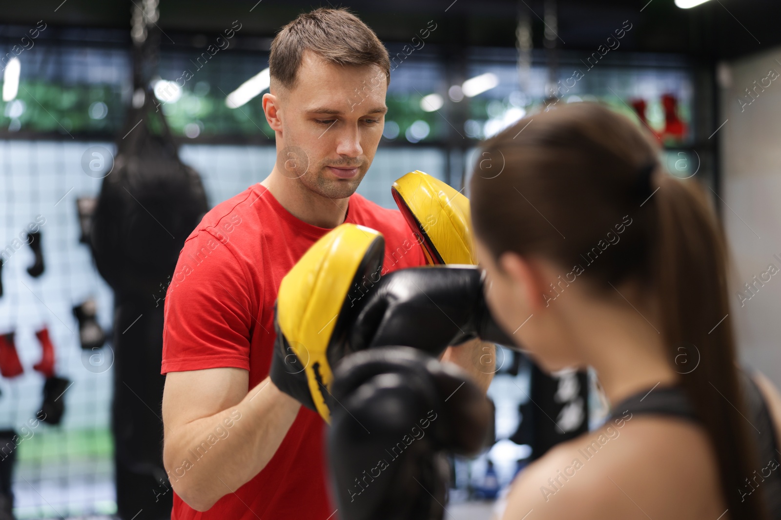 Young woman exercising with professional personal trainer in gym Photo of Young woman exercising with professional personal trainer in gym