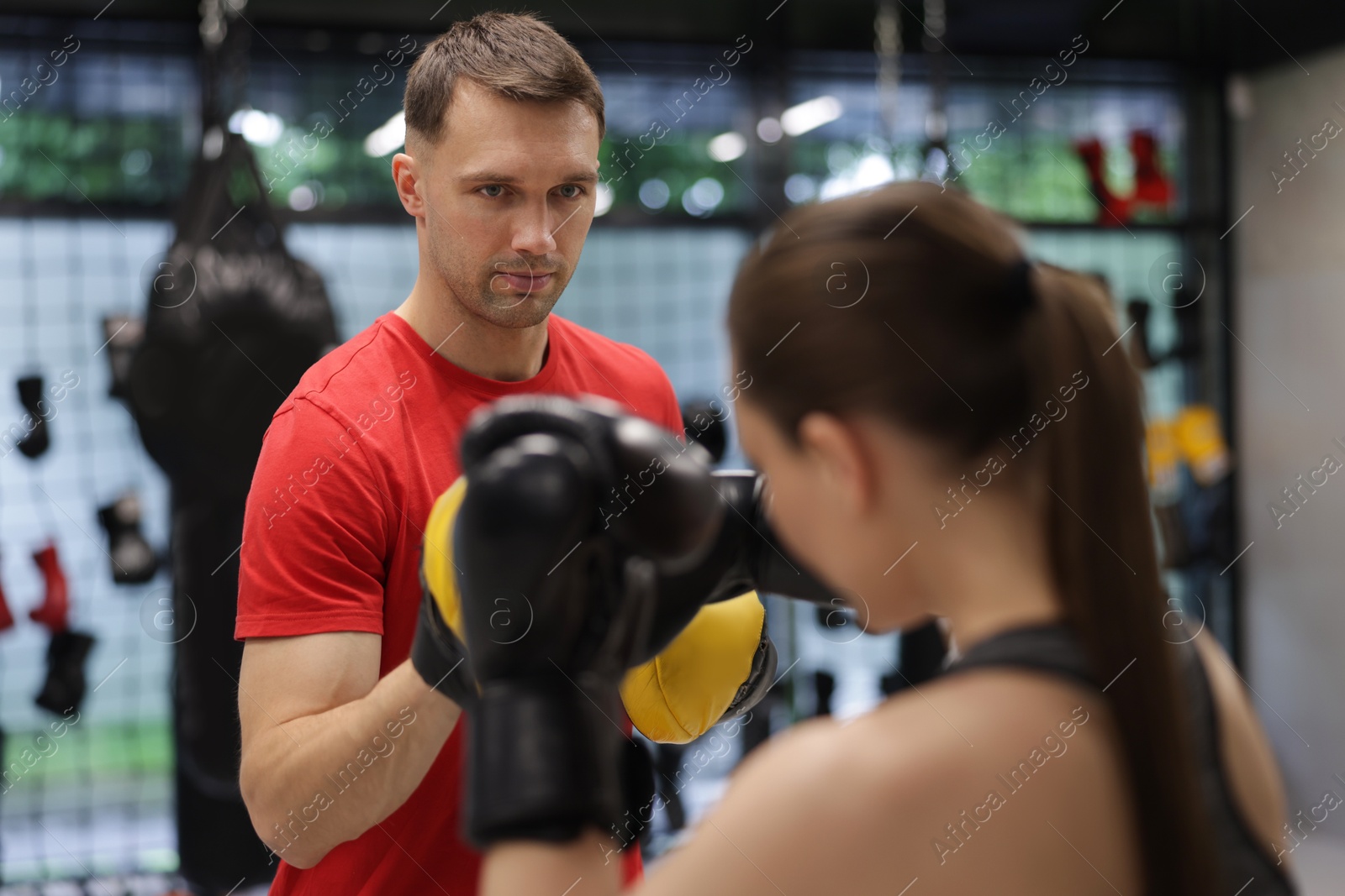 Young woman exercising with professional personal trainer in gym Photo of Young woman exercising with professional personal trainer in gym