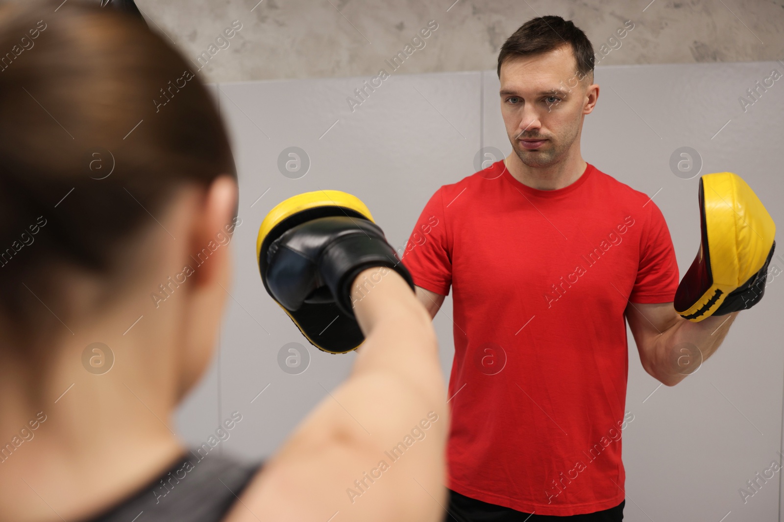Young woman exercising with professional personal trainer in gym, closeup Photo of Young woman exercising with professional personal trainer in gym, closeup