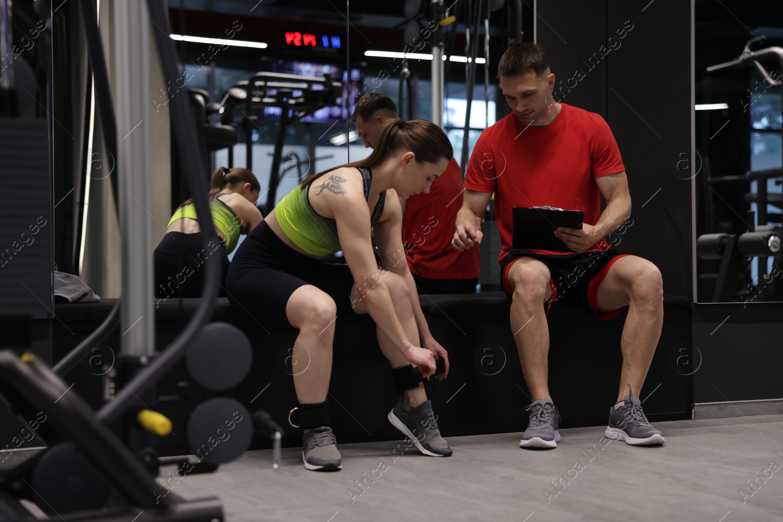 Young woman with professional personal trainer in gym Photo of Young woman with professional personal trainer in gym