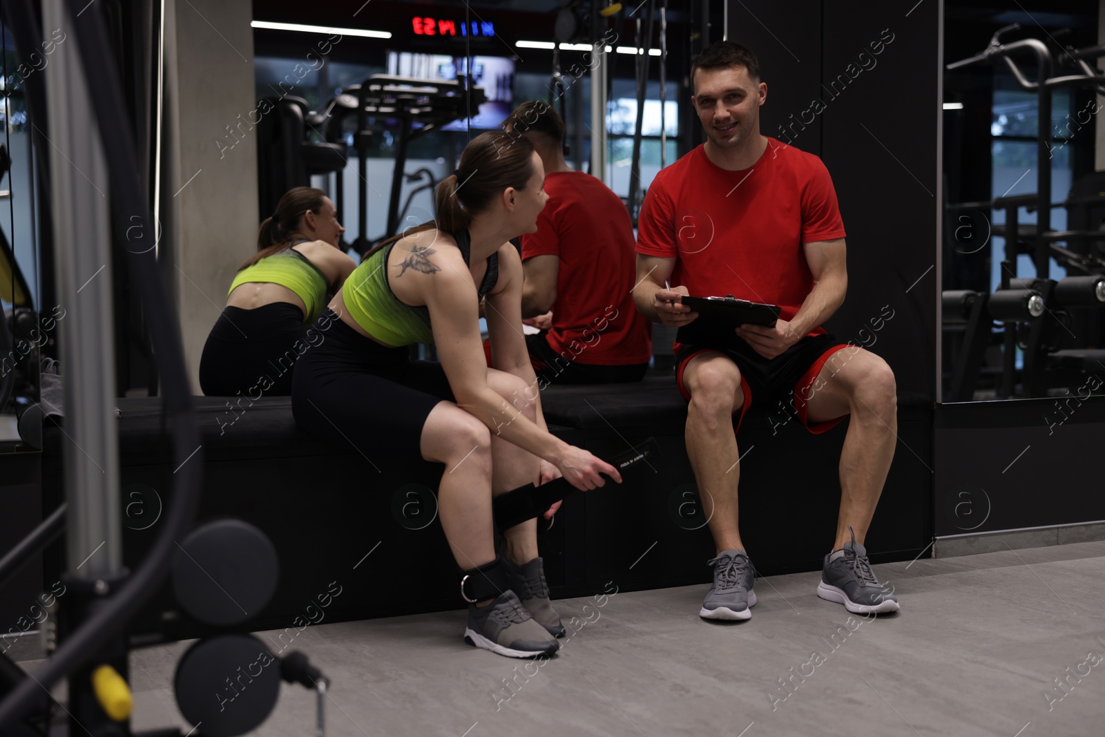 Young woman with professional personal trainer in gym Photo of Young woman with professional personal trainer in gym