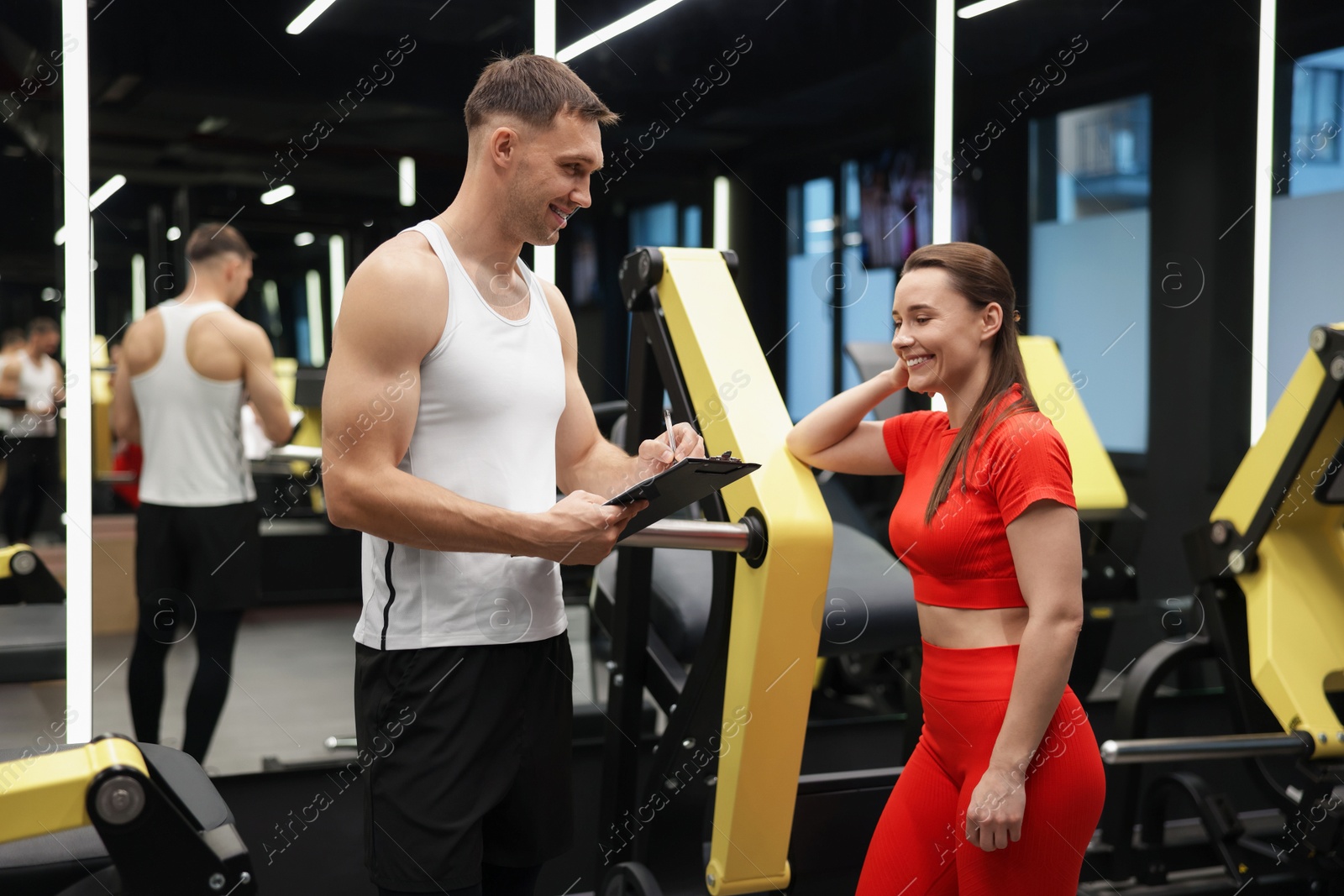Young woman with professional personal trainer in gym Photo of Young woman with professional personal trainer in gym