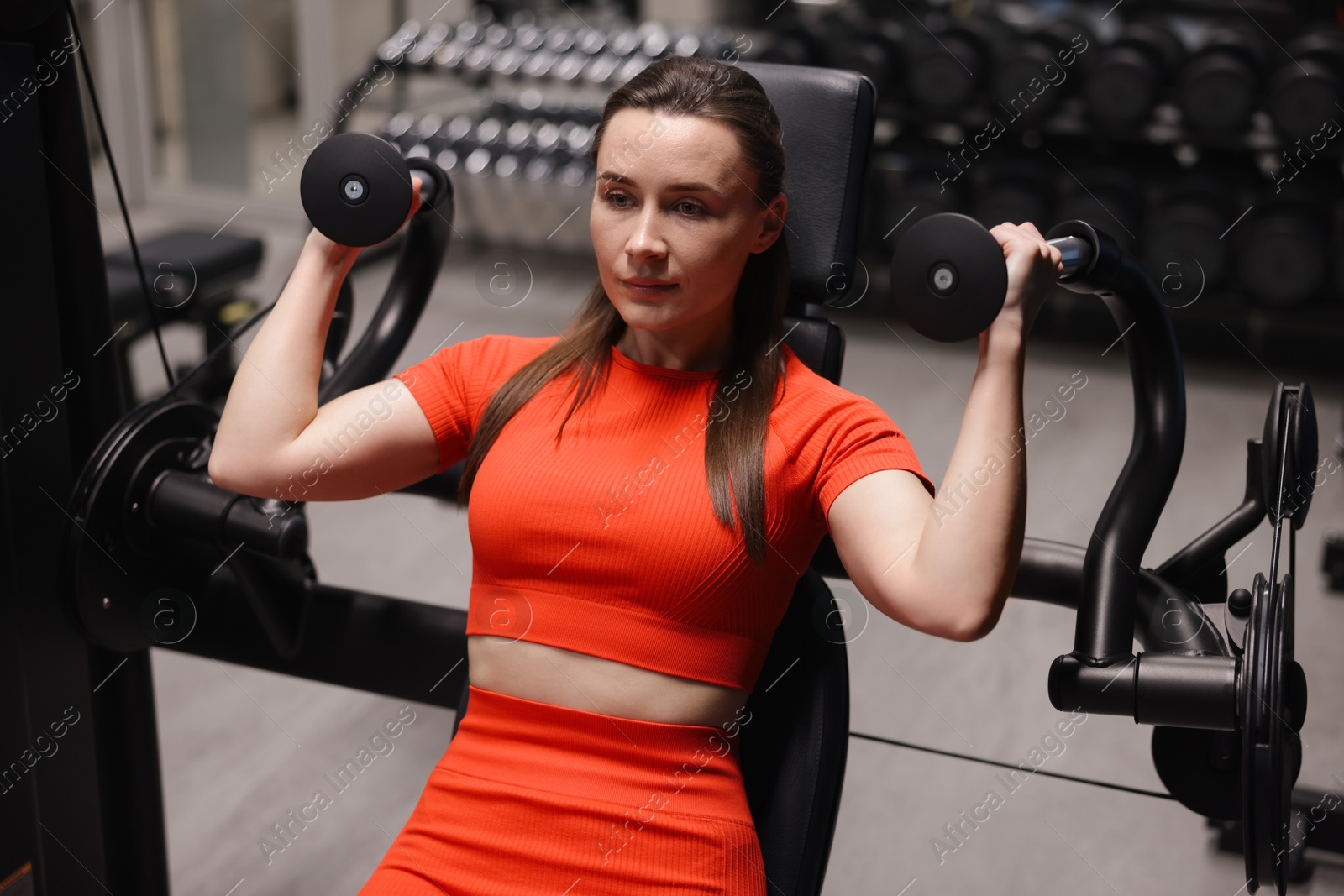 Young woman exercising with pull down machine in gym Photo of Young woman exercising with pull down machine in gym