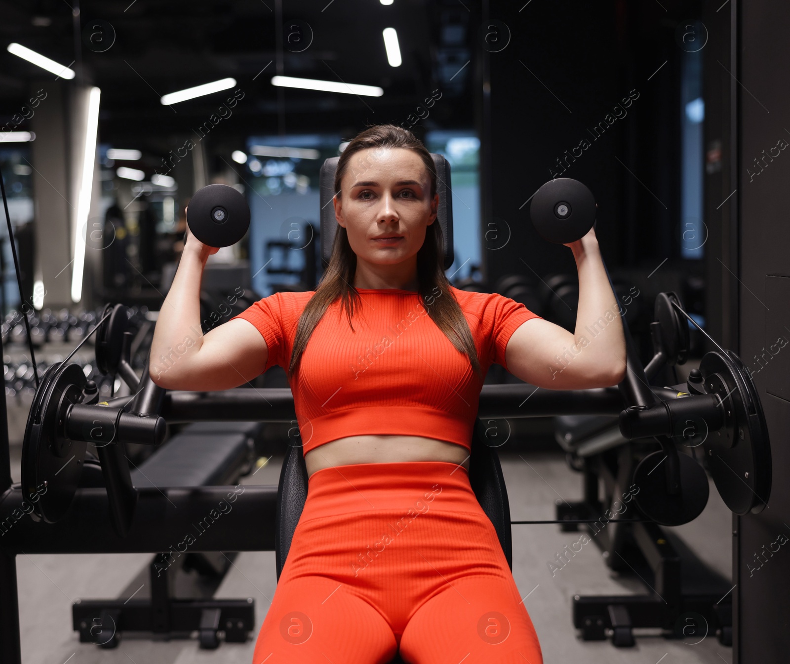 Young woman exercising with pull down machine in gym Photo of Young woman exercising with pull down machine in gym