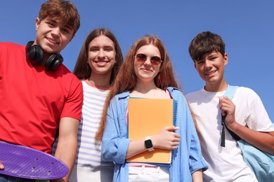 Photo of Group of teenagers walking together outdoors, low angle view