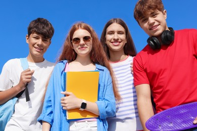 Photo of Group of teenagers walking together outdoors, low angle view