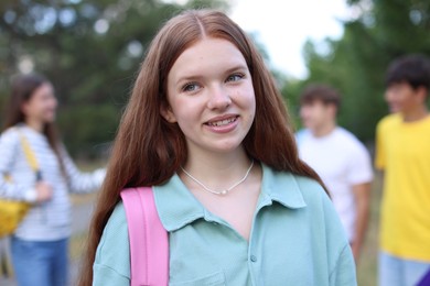 Photo of Portrait of teenager with backpack outdoors, selective focus