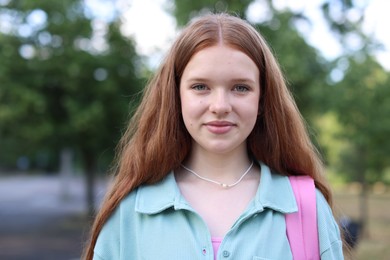 Photo of Portrait of teenage girl with backpack outdoors