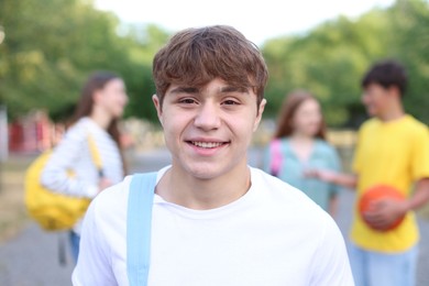 Photo of Portrait of teenager with backpack outdoors, selective focus