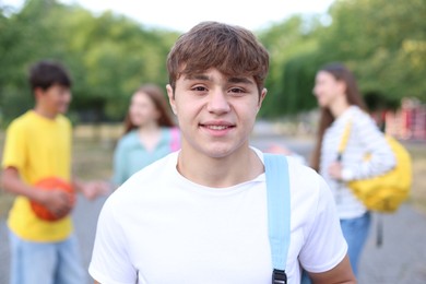 Photo of Portrait of teenager with backpack outdoors, selective focus