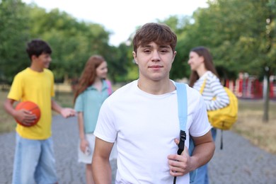 Photo of Portrait of teenager with backpack outdoors, selective focus