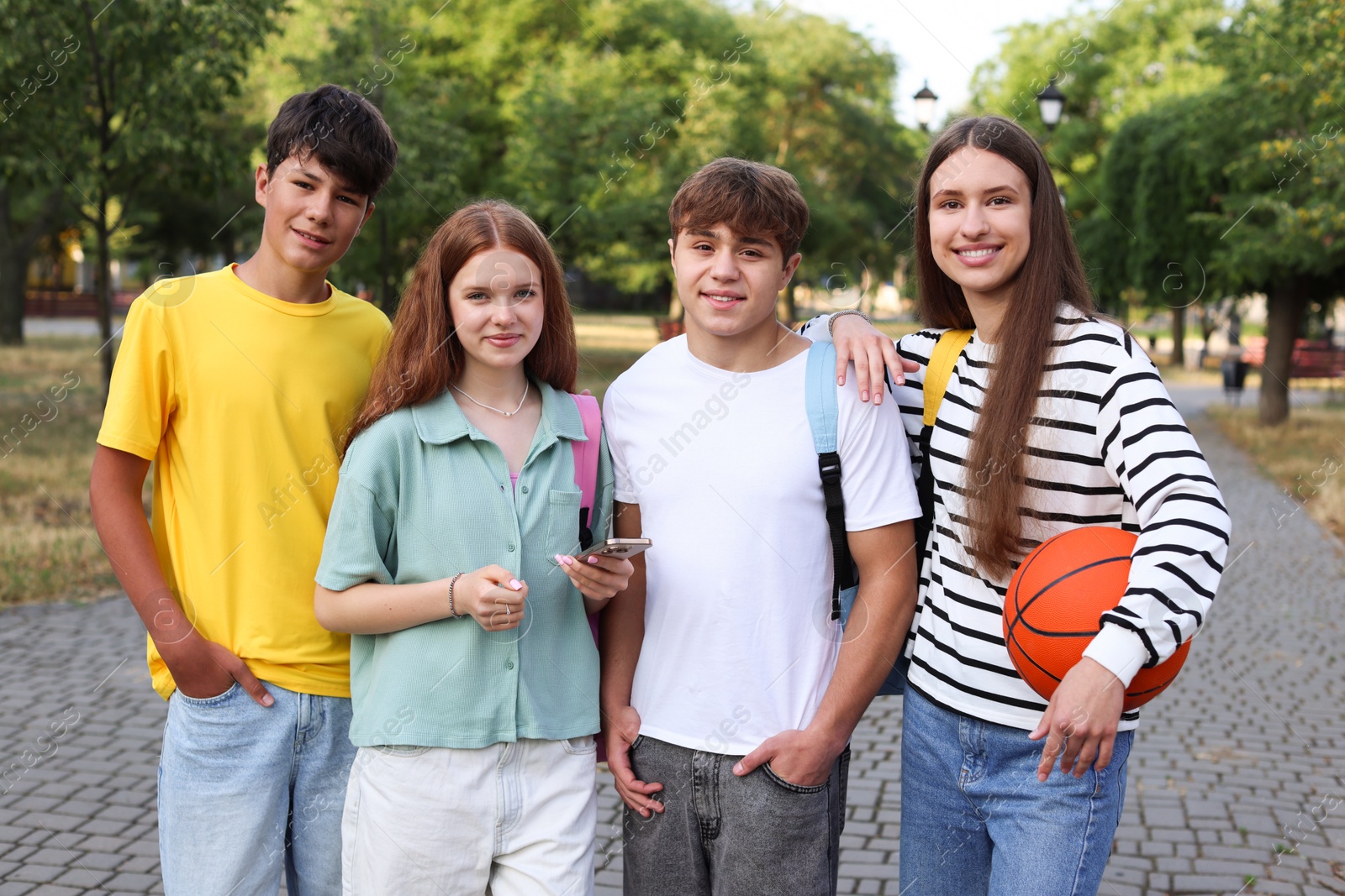 Group of teenagers walking together in park Photo of Group of teenagers walking together in park