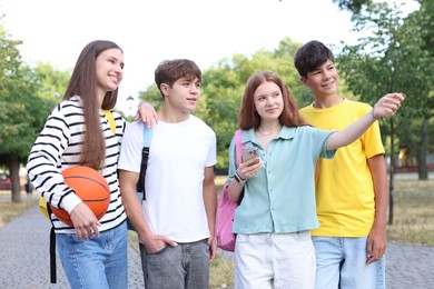 Photo of Group of teenagers walking together in park
