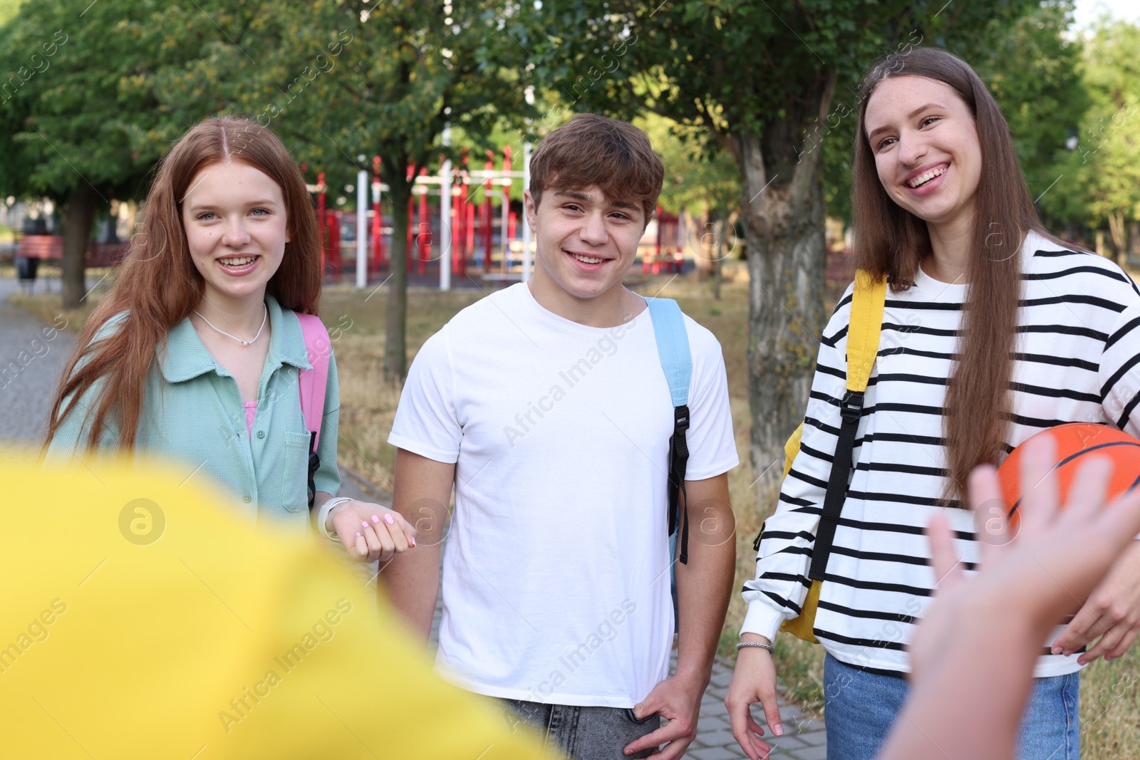 Group of teenagers spending time together in park Photo of Group of teenagers spending time together in park