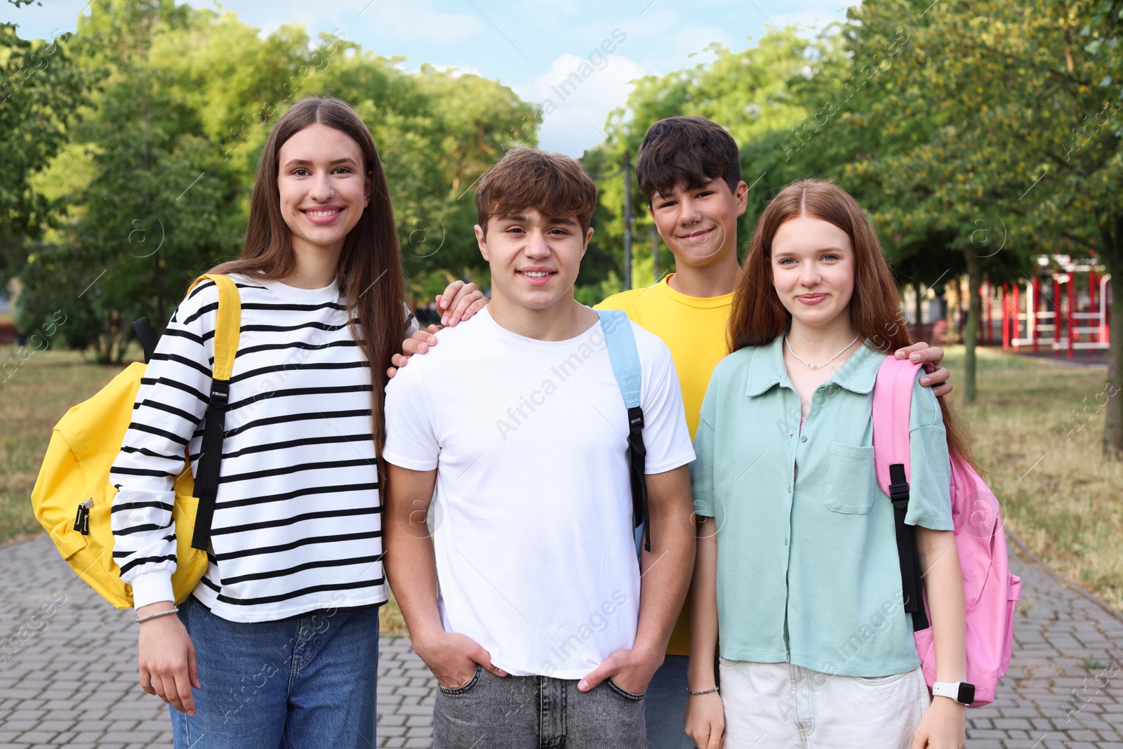 Group of teenagers spending time together in park Photo of Group of teenagers spending time together in park
