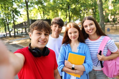 Photo of Group of teenagers taking selfie in park