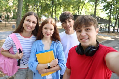Photo of Group of teenagers taking selfie in park
