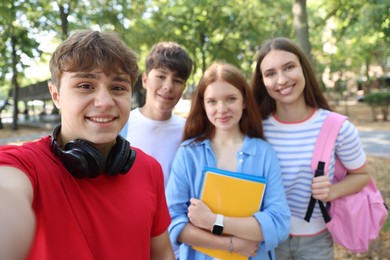 Photo of Group of teenagers taking selfie in park
