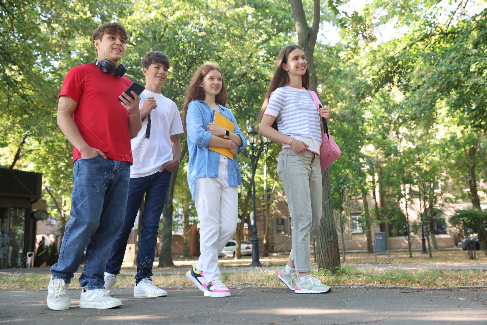 Group of teenagers walking together in park, low angle view Photo of Group of teenagers walking together in park, low angle view