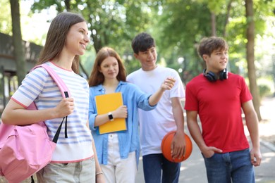 Photo of Group of teenagers walking together in park