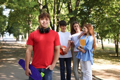 Photo of Group of teenagers walking together in park, selective focus