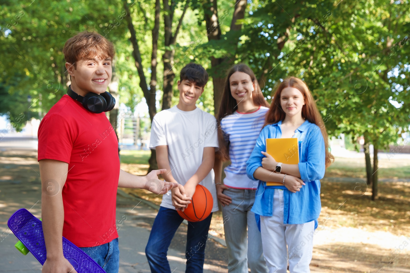 Group of teenagers walking together in park Photo of Group of teenagers walking together in park