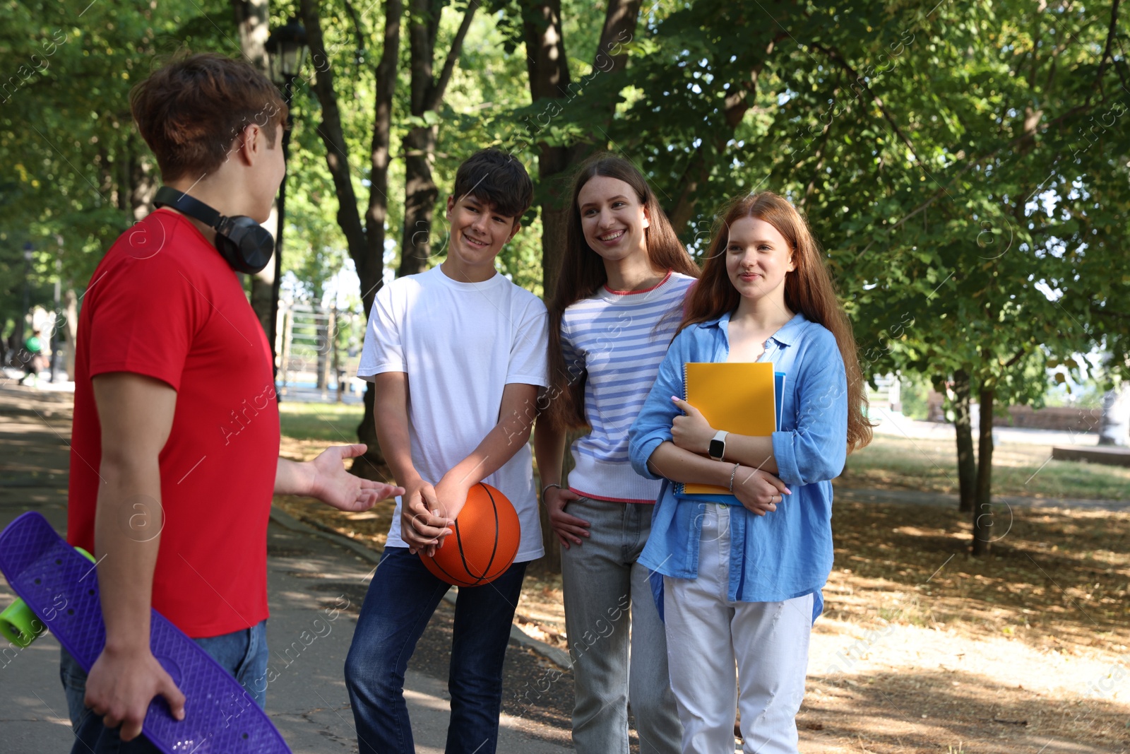 Group of teenagers walking together in park Photo of Group of teenagers walking together in park