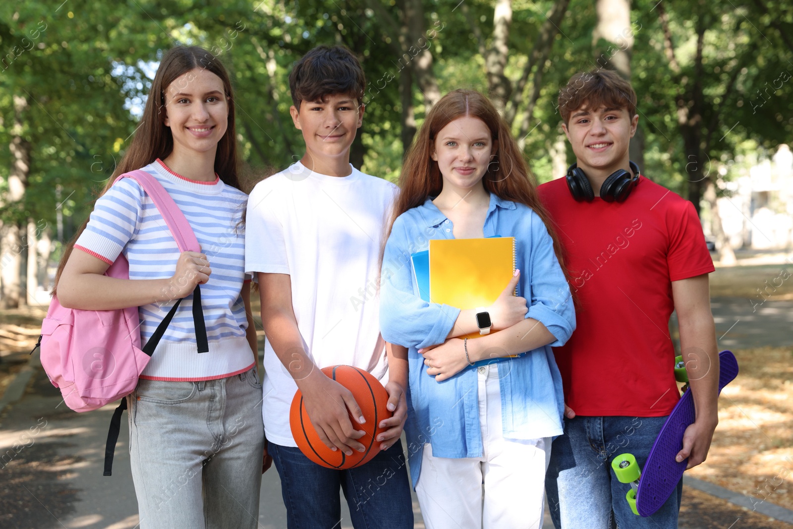 Group of teenagers walking together in park Photo of Group of teenagers walking together in park