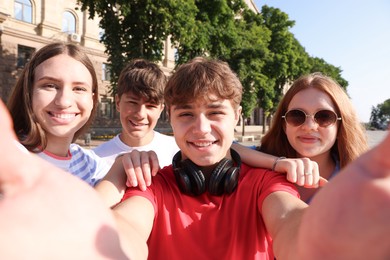 Photo of Group of teenagers taking selfie on city street