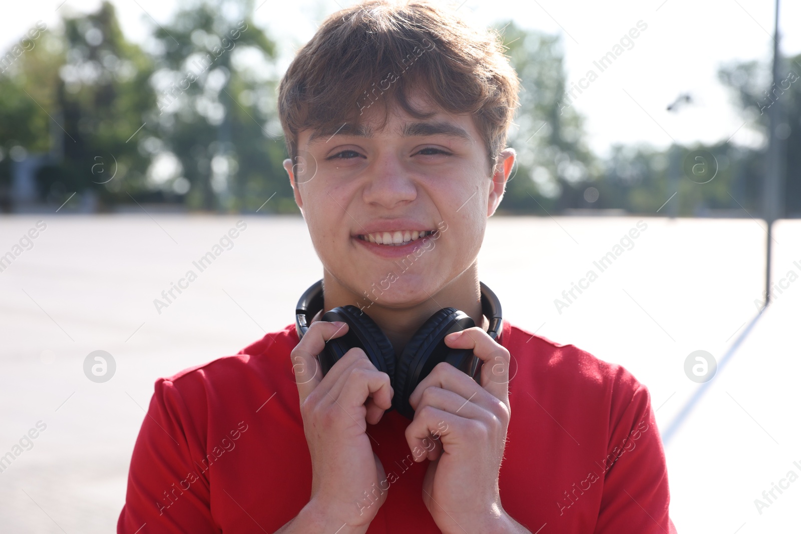 Portrait of teenage boy with headphones on city street Photo of Portrait of teenage boy with headphones on city street